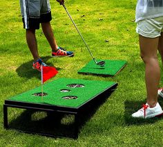 two people playing mini golf in the grass with their feet on the green tees