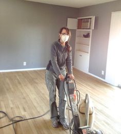 a woman vacuuming the floor in an empty room