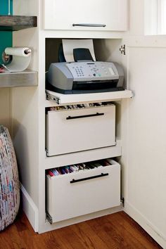 a white cabinet with two drawers and a printer on top