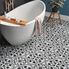 a bath tub sitting next to a wooden stool in a blue and white tiled bathroom