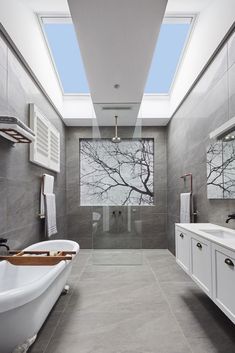 a bathroom with a skylight above the bathtub and sink, is shown on instagram