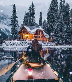 a person sitting in a boat on the water with a cabin in the back ground