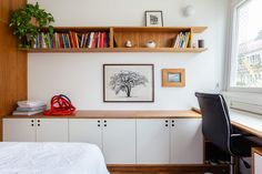 a bed sitting under a window next to a desk