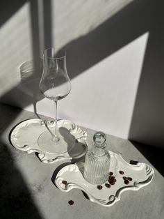 an empty wine glass sitting on top of a tray next to a bottle and spoon