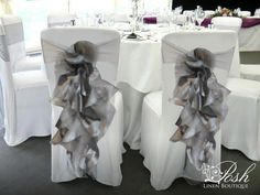 the chairs are decorated with white linens and ribbons