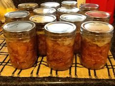 several jars filled with food sitting on top of a counter next to a yellow towel