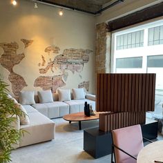 a living room filled with lots of furniture and a map on the wall behind it