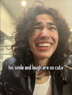 a woman with curly hair smiling and wearing a leather jacket, text reads his smile and laugh are so cute