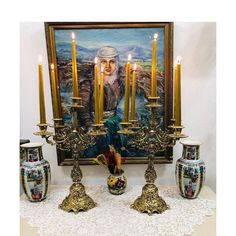 a painting and two vases on a table