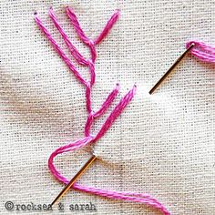 two knitting needles with pink yarn on top of each other and one needle in the middle