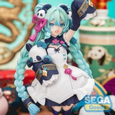 an anime figurine holding a stuffed animal on top of a table next to other toys