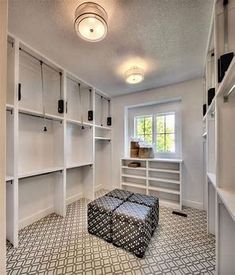 an empty walk in closet with white shelving