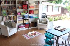 a living room filled with lots of furniture and bookshelves next to a window