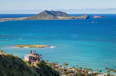 people are standing on the top of a hill looking out at the ocean and mountains