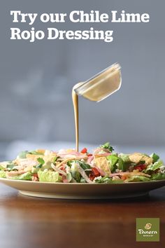 a salad with dressing being drizzled over it and the words try our chili lime rojo dressing