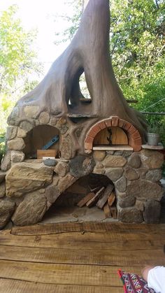 an outdoor oven built into the side of a tree trunk