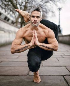 a man doing yoga poses with his hands in the air