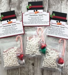 three bags filled with candy canes sitting on top of a wooden table