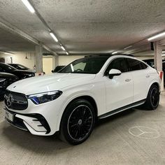 a white mercedes suv parked in a parking garage