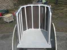 an empty white cart sitting on the side of a road