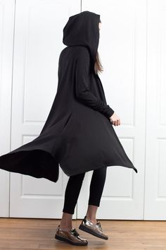 "Wool Cape, Knit Cardigan, Cloak with Hood This asymmetrical and modern cloak with hood has two side pockets, super comfy hood and thumb holes for a fabulous look. The model in the picture is 168cm. ⅼ 5.6 ft. tall and is wearing size S / color: black 🌟 INFO: * Worldwide EXPRESS shipping - please provide a phone number for shipping documents * US Sizing XS to 4XL - body size chart available below * We offer customization to Personal Measurements & Larger Sizes 5XL, 6XL, 7XL .... 🌟 MATERIAL Oversized Long Sleeve Black Cape, Black Long Sleeve Poncho For Spring, Spring Long Sleeve Black Poncho, Asymmetrical Sweater For Winter, Winter Stretch Asymmetrical Sweater, Asymmetrical Stretch Sweater For Winter, Asymmetrical Stretch Sweater For Fall, Stretch Asymmetrical Sweater For Winter, Stretch Asymmetrical Winter Sweater