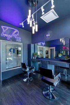 the interior of a hair salon with purple lighting