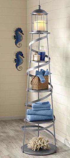 a towel rack with towels on it in the corner next to a lamp and other items