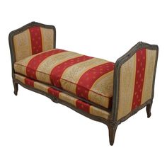 an antique style bench with red and gold striped upholstered fabric on the back