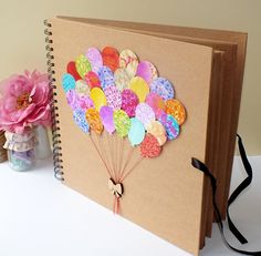 a photo album with balloons attached to it and the caption below that reads scrapbook / baby album