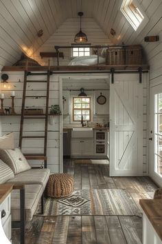 the interior of a tiny cabin with wood floors and white walls, wooden ladders leading up to the loft