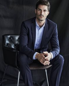 a man in a suit sitting on a chair