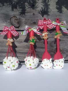 four red spoons decorated with gingerbread cookies and candy canes are lined up on a table