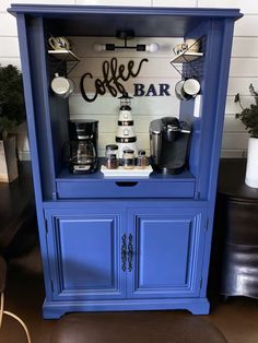 a coffee bar with blue cabinets and white walls