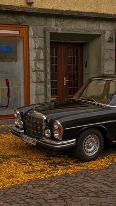 an old black car parked in front of a building