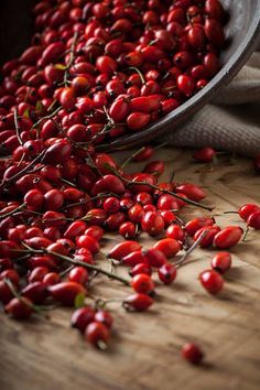 some red berries are on a wooden table