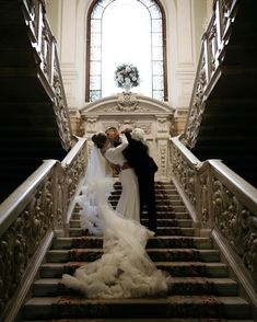 the bride and groom are kissing on the stairs