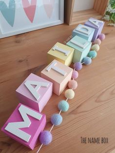 the name mail spelled out with pom - poms on a wooden floor in front of a frame