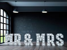 the letters mr and mrs are lit up in front of an open window