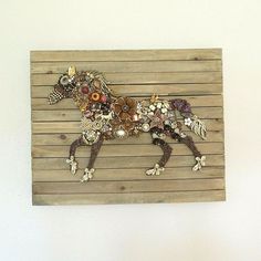 a wooden wall hanging with a horse made out of buttons