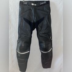 - Adjustable Belt With Snaps - Zipper Closure - Heavy-Weight Genuine Leather Shell - Comfort Stretch Panels In Crotch And Backs Of Knees - Removable Armor At Knees - Soft Armor Pads At Hips - Accordion Pleats At Knees And Low Back For Comfort And Flexibility - Reflective Stripes Below Knees - Full Circumference Pant-To-Jacket Zipper - Anatomic Stitching At Seat For Form-Fitting Comfort - Zipper Pockets At Front - Fully Lined Mesh - Zippered Back Leg For Easy On-Off Boots - Genuine Leather, 100% Black Moto Pants With Pockets, Black Moto Straight Leg Pants, Black Straight Leg Moto Pants, Black Moto Style Straight Leg Pants, Fitted Black Moto Pants, Leather Motorcycle Pants, Accordion Pleats, Motorcycle Pants, Jacket Zipper