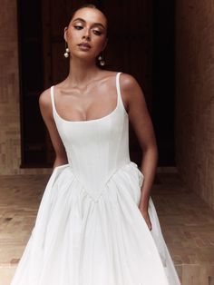 a woman in a white dress posing for the camera