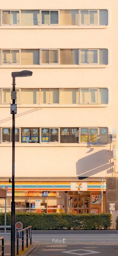 an empty parking lot in front of a large white building with many windows on it