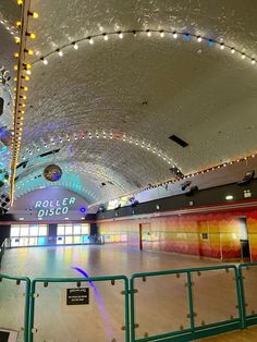 an indoor skating rink with lights on the ceiling