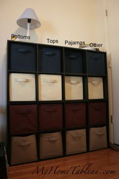 an organized shelf with many bins on top and bottom drawers below the lightshade