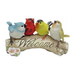 a group of birds sitting on top of a welcome sign