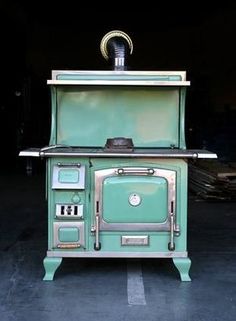 an old fashioned green stove sitting in a garage