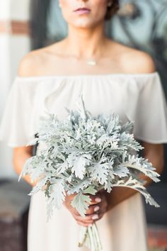 a woman holding a bouquet of flowers in her hands