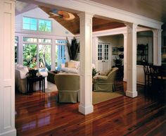 a living room filled with furniture next to a wooden floor covered in hard wood floors