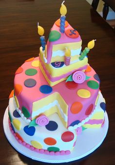 a birthday cake decorated with polka dots and candles