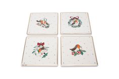 four white plates with birds and holly wreaths painted on them, one has a red bow